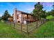 Beautiful home with a large deck and a rustic wooden fence surrounding the lush green lawn at 713 Aspen Rd, Golden, CO 80401