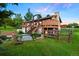 Multi-level home with a spacious deck, wooden stairs, and a surrounding green landscape at 713 Aspen Rd, Golden, CO 80401