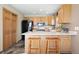 A bright kitchen featuring wooden cabinets, a black refrigerator, and a kitchen island with barstool seating at 713 Aspen Rd, Golden, CO 80401