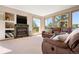 Bright living room with fireplace, built ins and large windows overlooking the lush backyard at 713 Aspen Rd, Golden, CO 80401