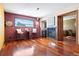Living room featuring a stone fireplace, hardwood floors, small bar and window view framed by a deep red accent wall at 713 Aspen Rd, Golden, CO 80401