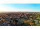 Sprawling aerial view of a residential area with tree-lined streets and the Denver skyline on the horizon at 220 Glencoe St, Denver, CO 80220