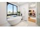 Luxurious bathroom featuring a freestanding tub, large windows, and a walk-in closet at 220 Glencoe St, Denver, CO 80220