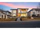 Modern two-story home with stone and wood accents, balcony, and landscaped front yard at 220 Glencoe St, Denver, CO 80220