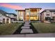 Stunning modern two-story home with large windows, a balcony, a manicured lawn and professional landscaping at 220 Glencoe St, Denver, CO 80220