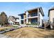 Modern two-story home featuring stone accents, wood siding, balcony, and a well-manicured front yard at 220 Glencoe St, Denver, CO 80220