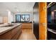 Modern kitchen featuring sleek cabinets, stainless steel appliances, a wine rack, and hardwood floors at 220 Glencoe St, Denver, CO 80220