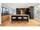 Contemporary kitchen with marble island, breakfast bar stools, black cabinets, and built-in appliances at 220 Glencoe St, Denver, CO 80220