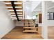 Striking modern staircase features wood treads, glass railings and custom metal supports at 220 Glencoe St, Denver, CO 80220