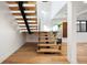 Modern staircase with wood treads, black supports, and glass railing at 220 Glencoe St, Denver, CO 80220