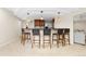 Open basement bar with seating, wooden cabinets, pendant lighting, and modern appliances at 2832 Danbury Ave, Highlands Ranch, CO 80126