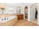 Bright bathroom with soaking tub, tile details, a glass enclosed shower, and access to a walk in closet at 2832 Danbury Ave, Highlands Ranch, CO 80126