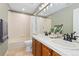 Bathroom featuring double sinks, vanity, large mirror, tile flooring, and shower-tub combination at 2832 Danbury Ave, Highlands Ranch, CO 80126