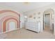 Bright bedroom showcasing a colorful mural, white dresser, and an arched doorway to a bathroom at 2832 Danbury Ave, Highlands Ranch, CO 80126