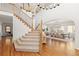 Elegant foyer with hardwood floors, a staircase, and a chandelier above the dining room at 2832 Danbury Ave, Highlands Ranch, CO 80126