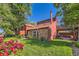 Charming home with a brick and wood exterior, mature landscaping, and a cozy outdoor patio space at 6225 E Mississippi Ave, Denver, CO 80224