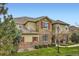 Two-story home featuring stone accents, red shutters, and manicured landscaping at 15496 W 66Th Dr # G, Arvada, CO 80007