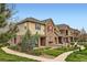 Street view of townhomes with stone accents, well-maintained landscaping, and a sidewalk at 15496 W 66Th Dr # G, Arvada, CO 80007