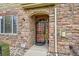 Close-up of front door with decorative ironwork and stone surround at 15496 W 66Th Dr # G, Arvada, CO 80007