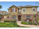 Charming townhome with a stone facade, red shutters, a well-manicured lawn, and a welcoming front entrance at 15496 W 66Th Dr # G, Arvada, CO 80007