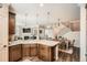 Open kitchen featuring a kitchen island, wooden cabinetry, and a view of the dining and living areas at 15496 W 66Th Dr # G, Arvada, CO 80007