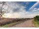 Picturesque community path with vibrant natural scenery and distant mountain range at 15496 W 66Th Dr # G, Arvada, CO 80007