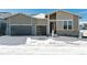 Two-story house with attached garage, light beige siding, and dark gray garage doors at 8845 Yellowcress St, Littleton, CO 80125