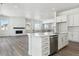 Modern kitchen with white cabinets, large island, and stainless steel appliances at 8845 Yellowcress St, Littleton, CO 80125