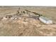 Aerial view showing the house, outbuildings, and dirt driveway in a rural setting at 1632 S County Road 137, Bennett, CO 80102