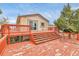 A spacious wooden deck offers an ideal setting for outdoor enjoyment and entertaining, featuring a vibrant red finish at 1632 S County Road 137, Bennett, CO 80102