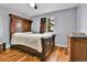 Bedroom with hardwood floors, an elegant wood bed frame, and a window providing plenty of natural light at 1632 S County Road 137, Bennett, CO 80102