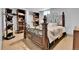 Bedroom featuring a wood bedframe, closet, and built in shelving for storage, with neutral-toned walls and flooring at 1632 S County Road 137, Bennett, CO 80102