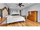 A large bedroom with hardwood floors, a large bed, a ceiling fan, and a large wood dresser at 1632 S County Road 137, Bennett, CO 80102