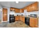 Functional kitchen with wooden cabinets, updated appliances, and durable tile flooring at 1632 S County Road 137, Bennett, CO 80102