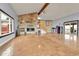 Open living room with tiled floors, a stone fireplace, and access to the outdoor deck area at 1632 S County Road 137, Bennett, CO 80102