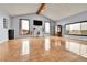 Bright, spacious living room with tiled floors, large windows, and a vaulted ceiling with wood beams at 1632 S County Road 137, Bennett, CO 80102