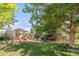 Landscaped backyard featuring a wooden play set and mature trees providing shade at 13971 Star Creek Dr, Broomfield, CO 80023