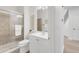 A modern bathroom with white fixtures, a glass-enclosed shower, and neutral tile, offering a clean and serene atmosphere at 13971 Star Creek Dr, Broomfield, CO 80023