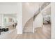 Bright entryway with hardwood floors, a curved staircase with iron railings, and views into the living and dining areas at 13971 Star Creek Dr, Broomfield, CO 80023