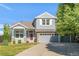 Charming two-story home featuring a well-maintained lawn, classic architectural details, and a welcoming red front door at 13971 Star Creek Dr, Broomfield, CO 80023