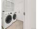A laundry room with a washer and dryer, white cabinets, and light wood floors, providing a functional space at 13971 Star Creek Dr, Broomfield, CO 80023