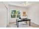 A well-lit office with a large window, a black desk with a gold lamp, and a soft rug, perfect for working from home at 13971 Star Creek Dr, Broomfield, CO 80023
