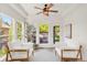 Cozy sunroom with ample natural light, comfortable seating, and a view of the beautifully landscaped backyard and patio at 13971 Star Creek Dr, Broomfield, CO 80023