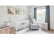 Bright Bedroom featuring a white crib, cozy armchair, and charming woodland-themed wall art at 4619 S Tabor Way, Morrison, CO 80465