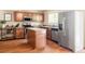 Spacious kitchen featuring wood cabinets, granite countertops, a stainless-steel refrigerator, and center island at 4619 S Tabor Way, Morrison, CO 80465