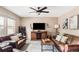 Cozy living room featuring plush leather sofas, a stylish media center, and a modern ceiling fan at 4619 S Tabor Way, Morrison, CO 80465