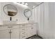 Bathroom featuring double sinks, modern fixtures, and a well-lit vanity with bright mirrors at 1179 S Fultondale Cir, Aurora, CO 80018
