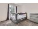Bright bedroom featuring a crib, window with tree view, and a gray dresser at 1179 S Fultondale Cir, Aurora, CO 80018