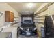 Spacious garage featuring a car, shelving for storage, and a refrigerator at 4655 Independence St # 3, Wheat Ridge, CO 80033
