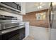 An updated kitchen with stainless steel appliances and a brick accent wall viewed from the range at 4655 Independence St # 3, Wheat Ridge, CO 80033